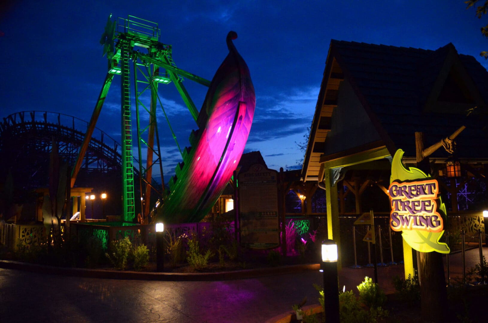 Colorful illuminated ferris wheel and attractions at night.