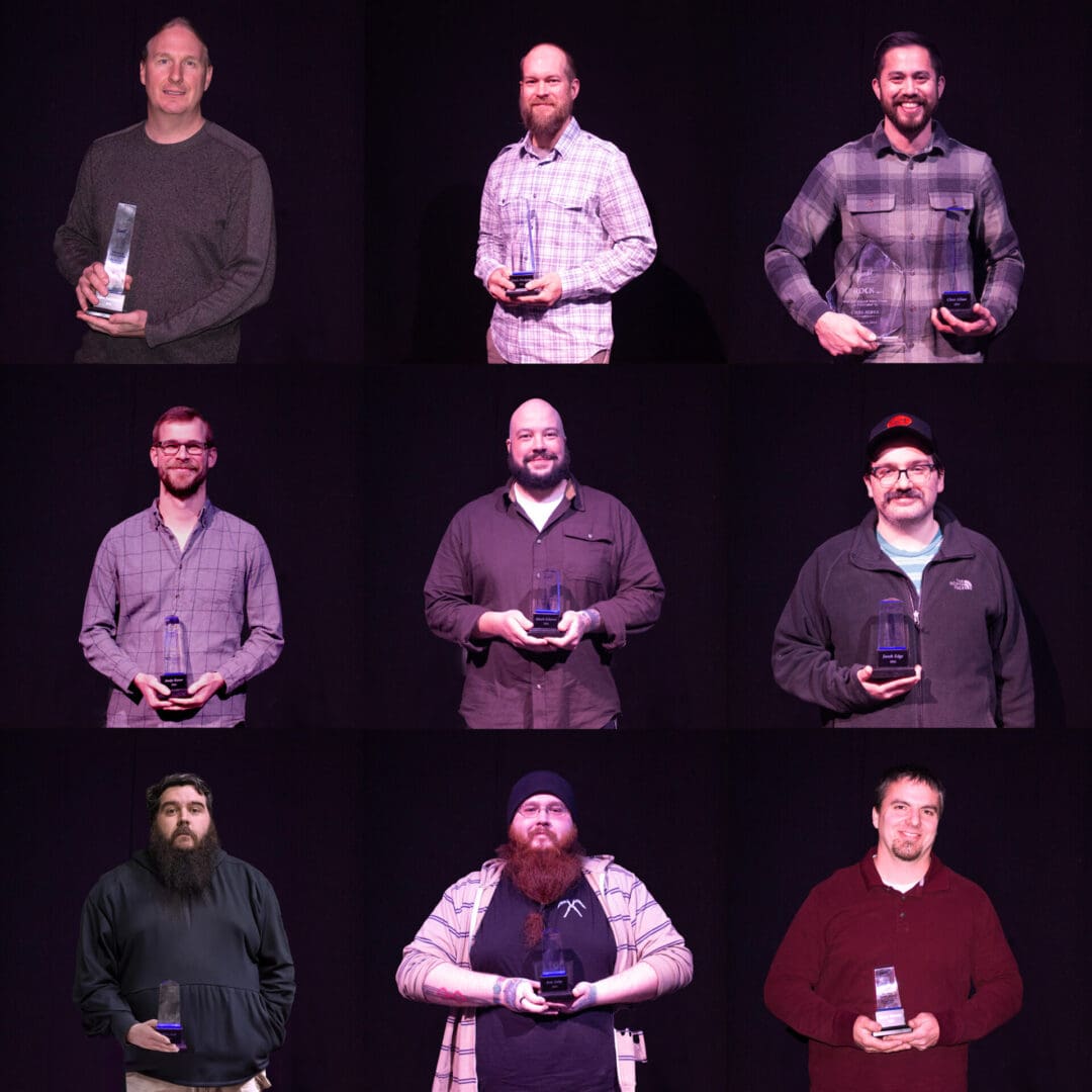 Seven men holding awards, posing in a grid against a black background.