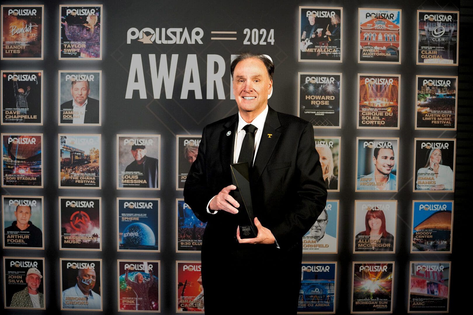 A man in a black suit holding an award at the Polestar 2024 Awards.