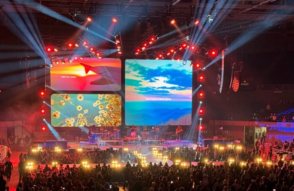 A vibrant concert stage with colorful screens and glowing lights.