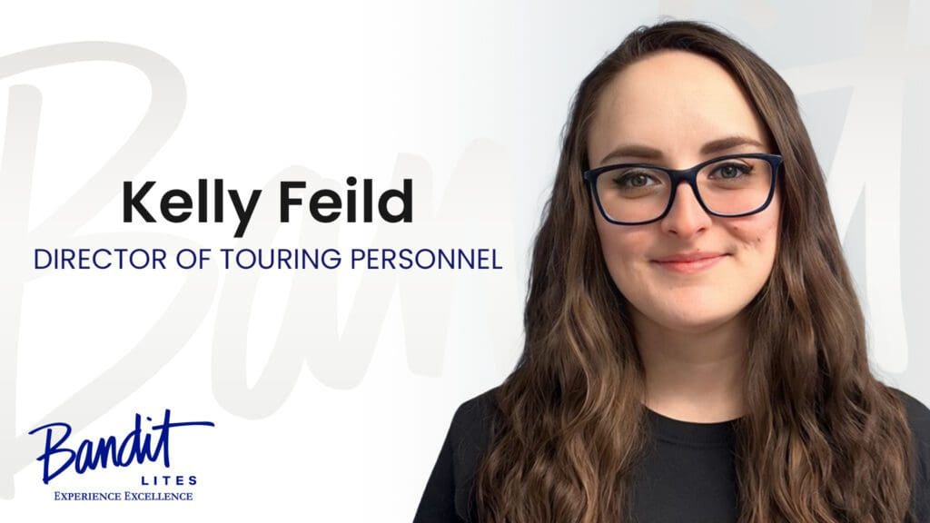Portrait of Kelly Feild, a member of touring personnel, wearing glasses and smiling.