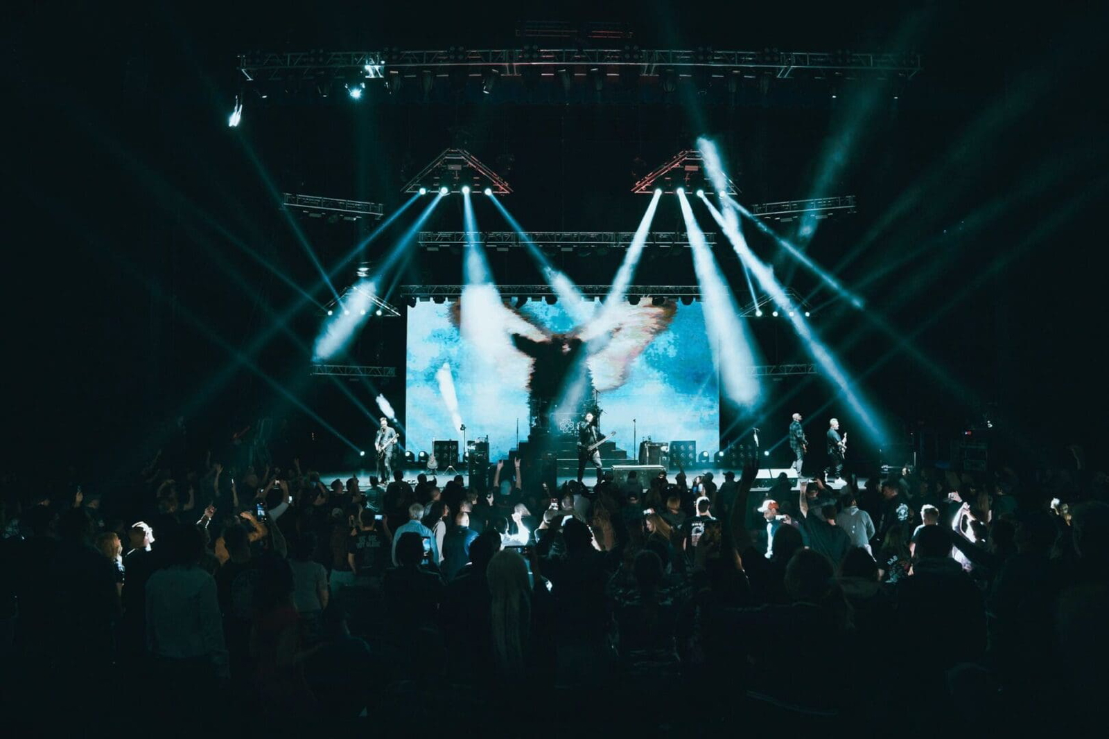 Performer energizes a packed concert with dynamic stage lighting.