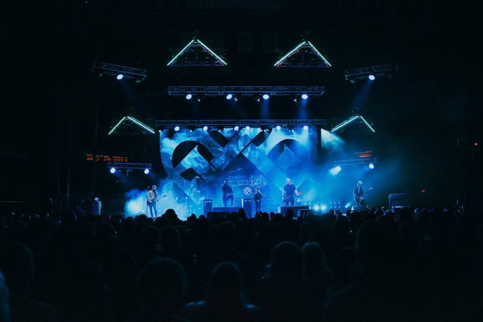 Crowd enjoying a vibrant live music concert with dynamic blue lighting.