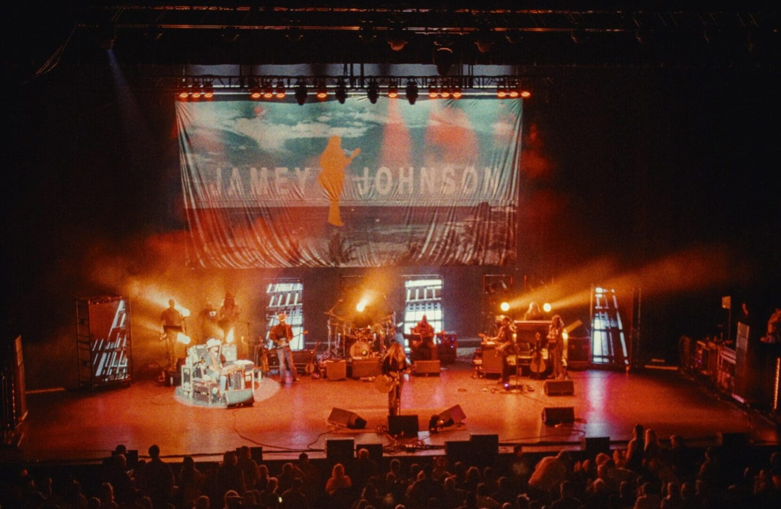 Live concert with band playing under vibrant stage lights.