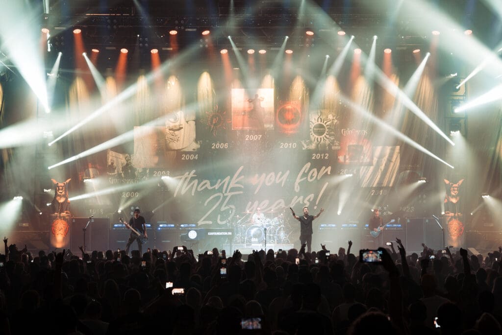A live concert with bright stage lights and a large crowd.