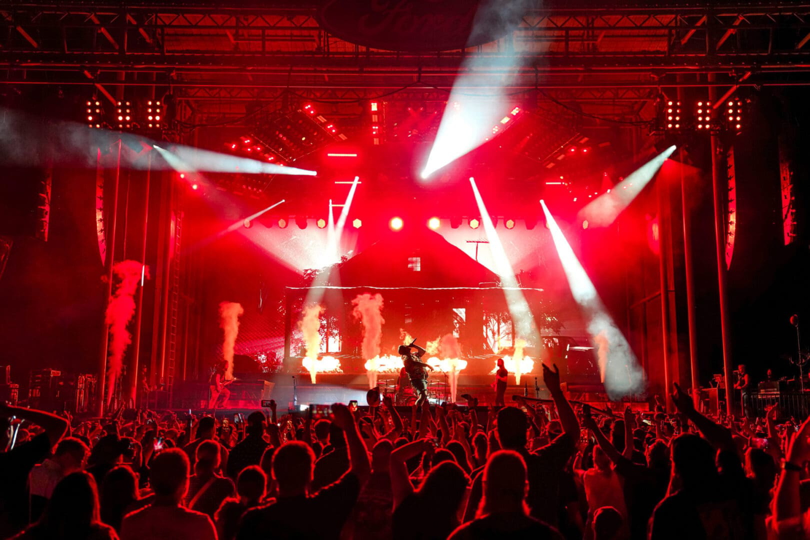 A lively concert with bright red lights and an excited crowd.