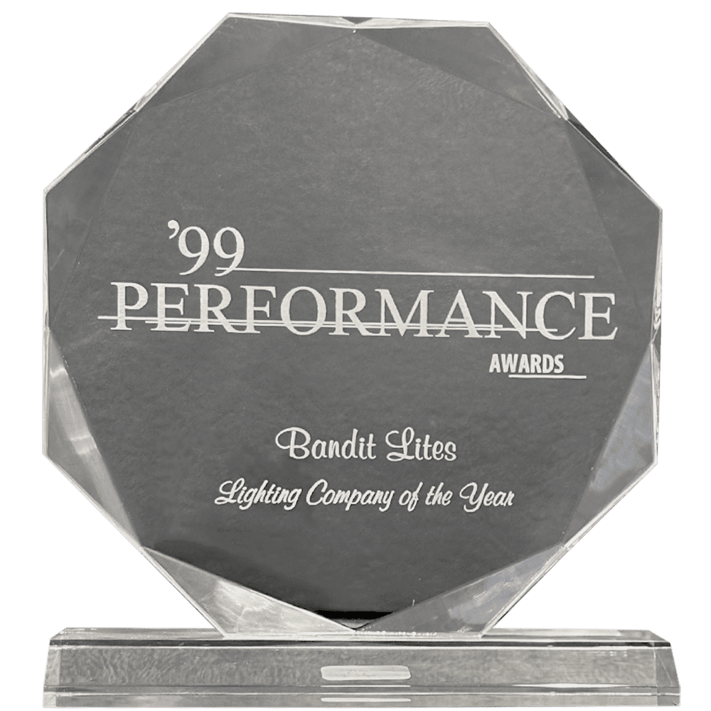 A gray octagonal award for lighting company performance in 1999.