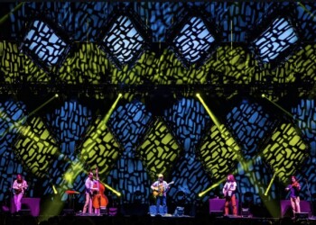 A colorful stage performance with vibrant lighting effects and musicians.