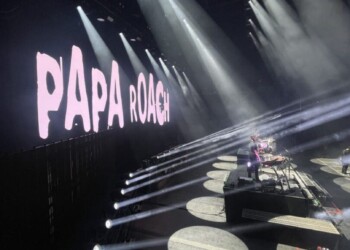 Papa Roach performing live on stage with dramatic lighting effects.