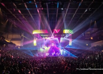 A vibrant music festival with colorful lights and a large crowd.