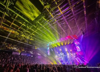 A vibrant concert with colorful lights illuminating the crowd and stage.