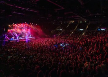A vibrant concert with a large crowd and colorful stage lights.