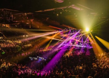A vibrant concert with colorful lights and a large crowd.