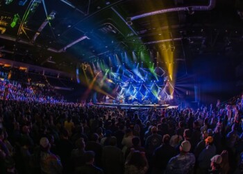 A live concert with vibrant stage lights and a large audience.