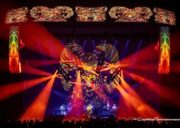A vibrant concert stage with colorful lights and a large decorative backdrop.
