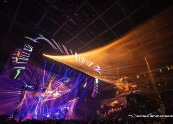 A vibrant concert with colorful lights and a large crowd inside an arena.