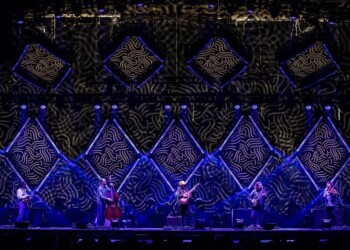 Live band performing on a stage with decorative diamond-shaped lighting.