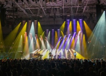 A lively concert with colorful stage lights and a cheering crowd.