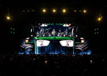 A large tractor displayed on a stage with people around it.