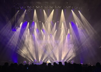 A vibrant stage with colorful lights and smoke effects during a live show.