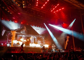 A lively concert stage with red lights and smoke effects.