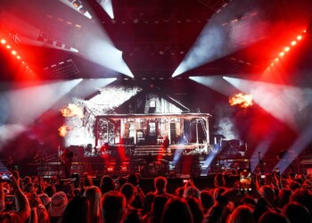 A vibrant concert stage with bright lights and a large crowd.