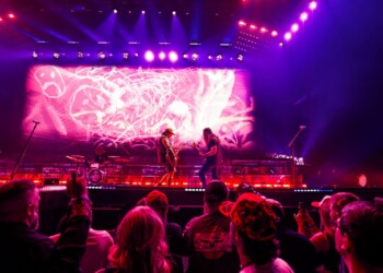 A vibrant concert stage with performers and colorful lighting effects.