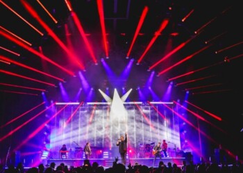 Vibrant stage with bright lights and performers at a live concert.