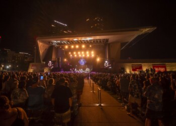 Crowd watching a live music concert at an outdoor venue at night.
