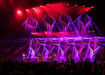 Photo: Jesse Faatz A vibrant concert stage with purple and red lighting effects.