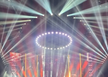 A vibrant concert with dynamic lights and a large audience.