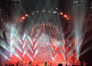 A vibrant rock concert with dramatic lighting and a large crowd.